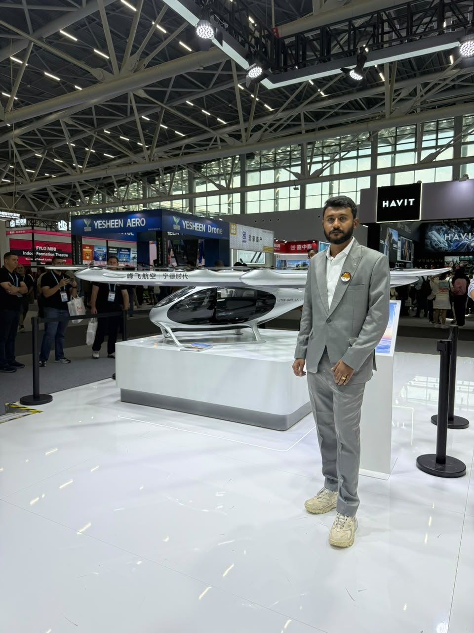 Bollam Rishithej beside a passenger air-mobility vehicle on display at the Yesheen Aero stand, 140th Canton Fair, Guangzhou